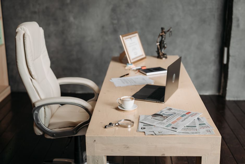 A small, heavy anchor sits on top of a pile of legal papers on a professional desk, visually representing the psychological concept of an anchoring bias in negotiations.